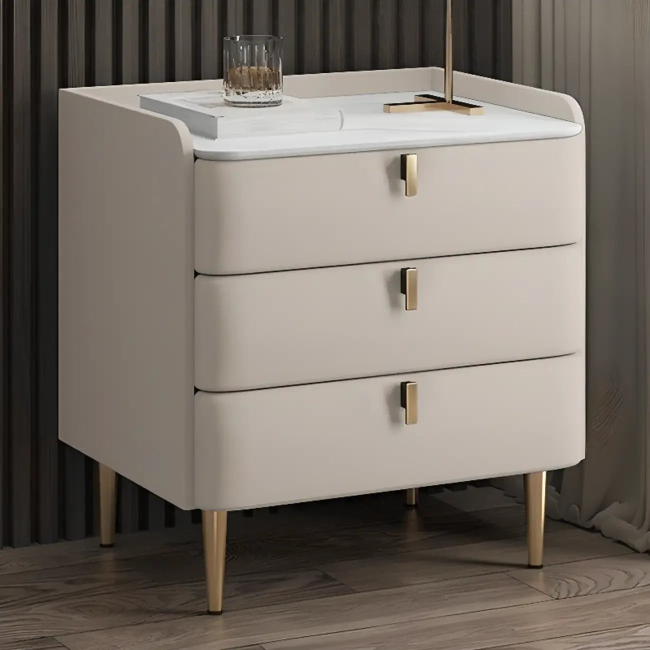 Table de chevet moderne à 3 tiroirs avec plateau en pierre, finitions dorées et revêtement en cuir.