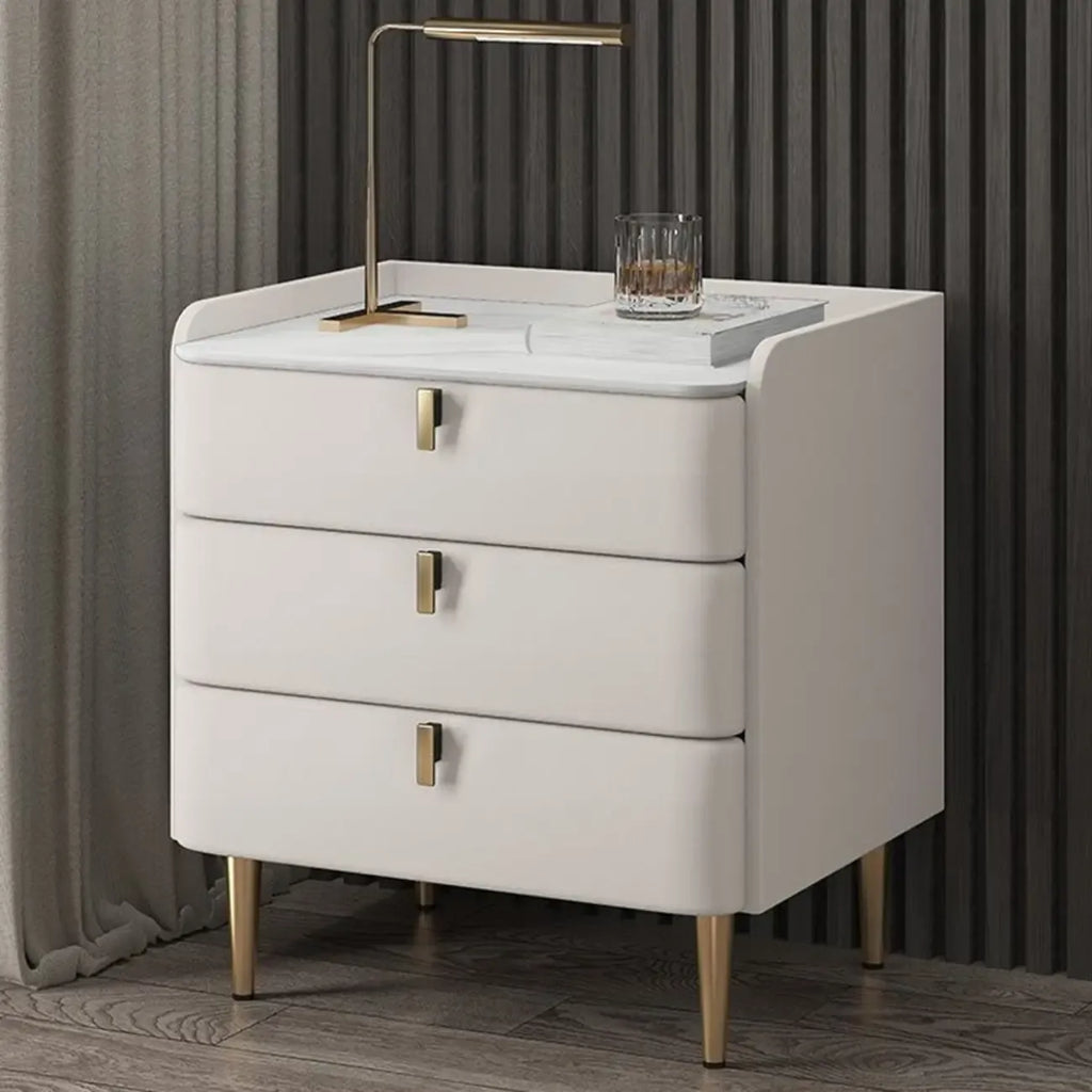 Table de chevet moderne à 3 tiroirs avec plateau en pierre, finitions dorées et revêtement en cuir.