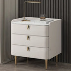 Table de chevet moderne à 3 tiroirs avec plateau en pierre, finitions dorées et revêtement en cuir.